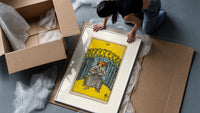 Seated man before nine golden cups framed print being unpacked from protective bubble wrap and a box