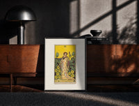 Black-framed Woman with falcon in vineyard print on a moody console with designer coffee-table books