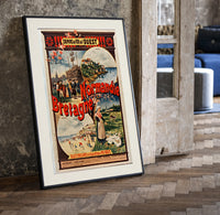 French coastal travel scenes print in a black frame leaning beside a vintage door on parquet