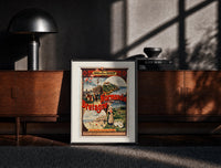 Black-framed French coastal travel scenes print on a moody console with designer coffee-table books
