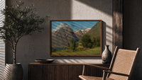 Norwegian fjord mountain landscape with cabin print in a wood frame above a fluted sideboard beside an olive tree