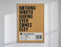 Motivational typography shoe box label poster in a slim frame on a bright wall with soft window light
