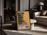 Motivational typography shoe box label print in a black frame leaning on a travertine table in a sunlit lounge