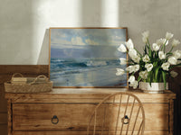 Ocean waves crashing on beach print in an oak frame on a farmhouse dresser beside white tulips