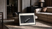 advertising blimp airship print in a slim black frame leaning on a travertine coffee table