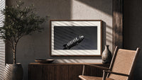 advertising blimp airship print in a wood frame above a fluted sideboard beside an olive tree
