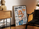 Brass-framed Nami from One Piece anime print leaning in a warm styled corner by a sculpture