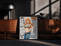 Black-framed Nami from One Piece anime print on a moody console with designer coffee-table books