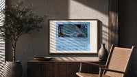 Elegant woman holding hand mirror print in a wood frame above a fluted sideboard beside an olive tree
