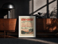 Black-framed French Auvergne railway travel advertisement print on a moody console with designer coffee-table books