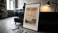 French Auvergne railway travel advertisement print in a slim black frame leaning on a dark sofa in a concrete print studio