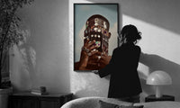 Ornate Headpiece with Fringe and Rings print in a slim black frame being hung on a sunlit wall in a monochrome room