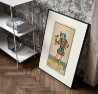 Page holding cup with fish poster in a black frame leaning beside a shelf in a raw-plaster loft