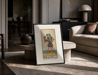 Page holding cup with fish print in a black frame leaning on a travertine table in a sunlit lounge