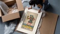 Page holding cup with fish framed print being unpacked from protective bubble wrap and a box