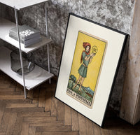 Youth holding pentacle coin poster in a black frame leaning beside a shelf in a raw-plaster loft