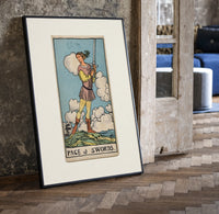 Young figure holding upraised sword print in a black frame leaning beside a vintage door on parquet