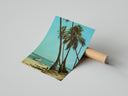 Beach scene with palm trees and surfers poster styled above furniture in a modern room