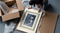 Elegant woman with perfume bottle framed print being unpacked from protective bubble wrap and a box