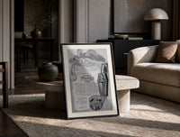 Reclining Egyptian woman perfume advertisement print in a black frame leaning on a travertine table in a sunlit lounge