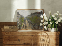 Busy Parisian boulevard cityscape print in an oak frame on a farmhouse dresser beside white tulips