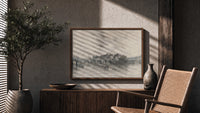 River bridge with city skyline print in a wood frame above a fluted sideboard beside an olive tree