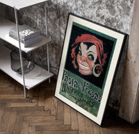Grinning woman's face with earring poster in a black frame leaning beside a shelf in a raw-plaster loft