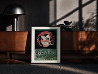 Black-framed Grinning woman's face with earring print on a moody console with designer coffee-table books