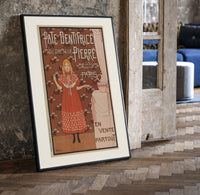 Young girl in red nightgown print in a black frame leaning beside a vintage door on parquet