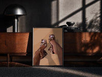 Black-framed Cowhide Mules and Chain Anklet print on the floor in front of a dark wooden console