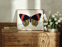 Butterfly with patterned wings print in an oak frame on a farmhouse dresser beside white tulips