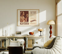 Woman holding hand mirror print in an oak frame above a mid-century book console with a vintage radio