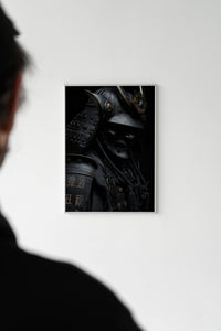 Person standing before a dark samurai armor print with kanji detail hung on a white wall