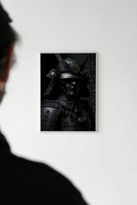 Person viewing a dark samurai warrior print with a crescent horn helmet on a white wall