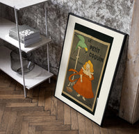 Girl in red dress eating biscuit poster in a black frame leaning beside a shelf in a raw-plaster loft