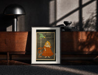 Black-framed Girl in red dress eating biscuit print on a moody console with designer coffee-table books