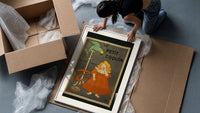 Girl in red dress eating biscuit framed print being unpacked from protective bubble wrap and a box