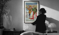 Pilgrim Couple with Turkey print in a slim black frame being hung on a sunlit wall in a monochrome room