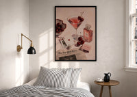 Pink Drink, Cherries and Perfume print in a black frame above a bed with striped linens
