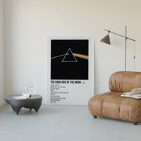 Pink Floyd Dark Side of the Moon Prism poster framed above a tan leather living-room couch