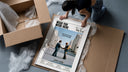 Pink Floyd Wish You Were Here Burning Handshake framed print being unboxed from protective packaging