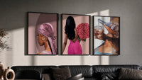 Pink Headscarf, Roses and Drink Set of 3 in black frames on a grey wall above a leather sofa
