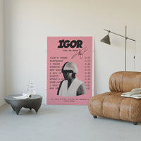 Pink Tyler the Creator IGOR Tracklist poster framed above a tan leather living-room couch