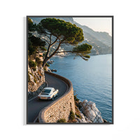White Porsche 911 sports car cornering a winding Italian coastal road above azure Mediterranean water in a wall print