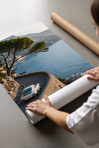 Woman opening a Porsche 911 Amalfi coast poster from a crush-resistant brown shipping tube indoors