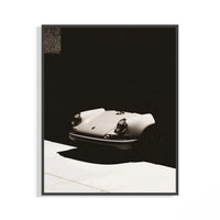 Vintage white Porsche 911 front view against dramatic black shadows, shown in a frame for display