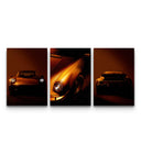 Three Porsche 911 poster prints showing front, side, and rear angles in dramatic orange tones on white background