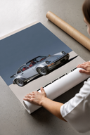 Woman revealing a Porsche 911 Turbo Classic Silver wall art poster from protective brown cardboard packaging