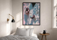 Pouring Tea in a White Robe print in a black frame above a bed with striped linens, a brass wall lamp and a sunlit window