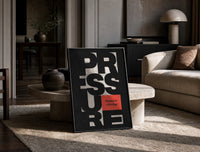 Pressure Is a Privilege print on the floor, leaning against a travertine table